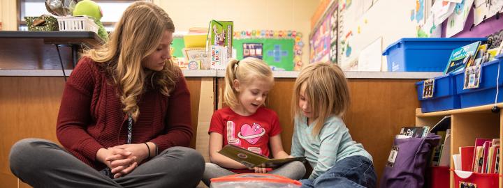 Teacher and young students reading