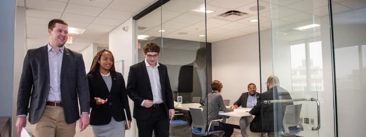 Business students walk down a hallway.