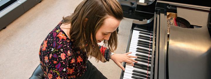 Student sitting at piano playing.