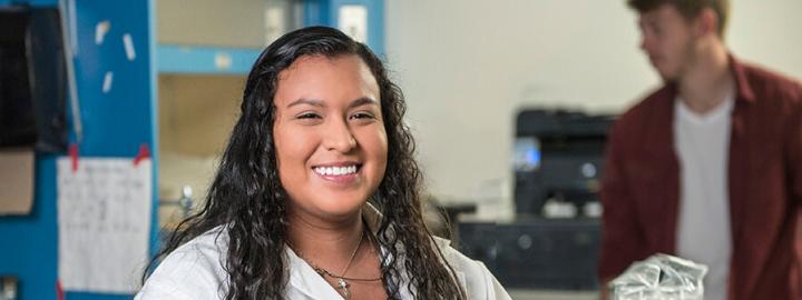 Student standing in a lab coat