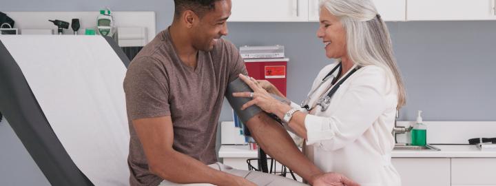 Woman taking blood pressure of patient