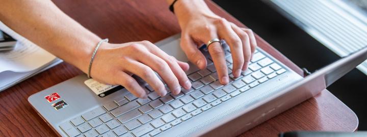 Someone is typing on a laptop computer.