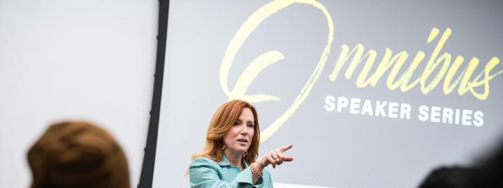 Omnibus logo on a screen behind guest speaker in the IdeaSpace.