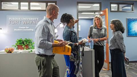 Faculty and staff standing at the front desk of the counseling center on campus.