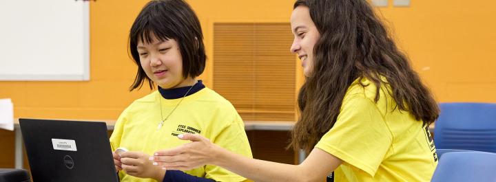 Student and Camp Lead working together on coding a drone
