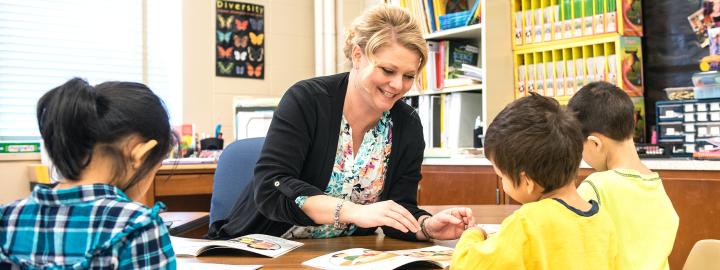 A female teacher with students at a table