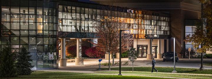 Helmke Library and the skybridge fully lit up at night.