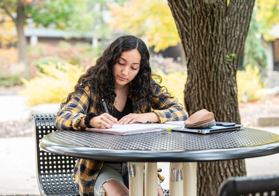 Student writing outdoors