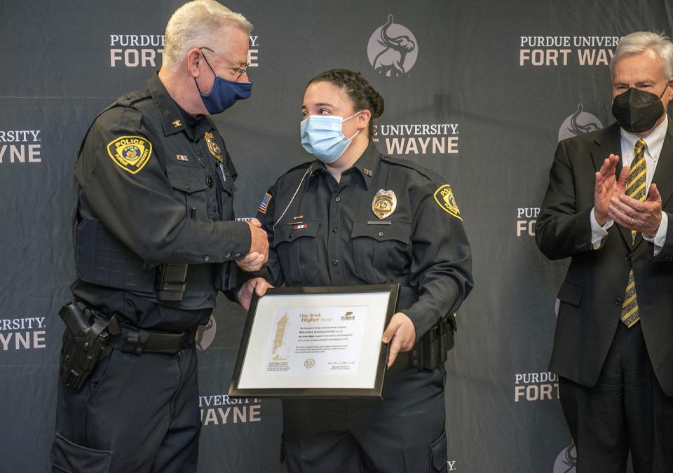 Officer BreAnne Wojnarowski is presented with the One Brick Higher Award by Chief John Cox