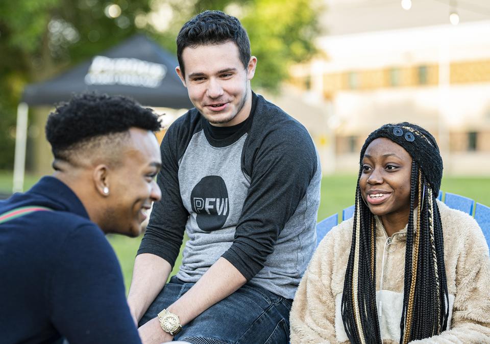 Students sitting outside having a conversation.