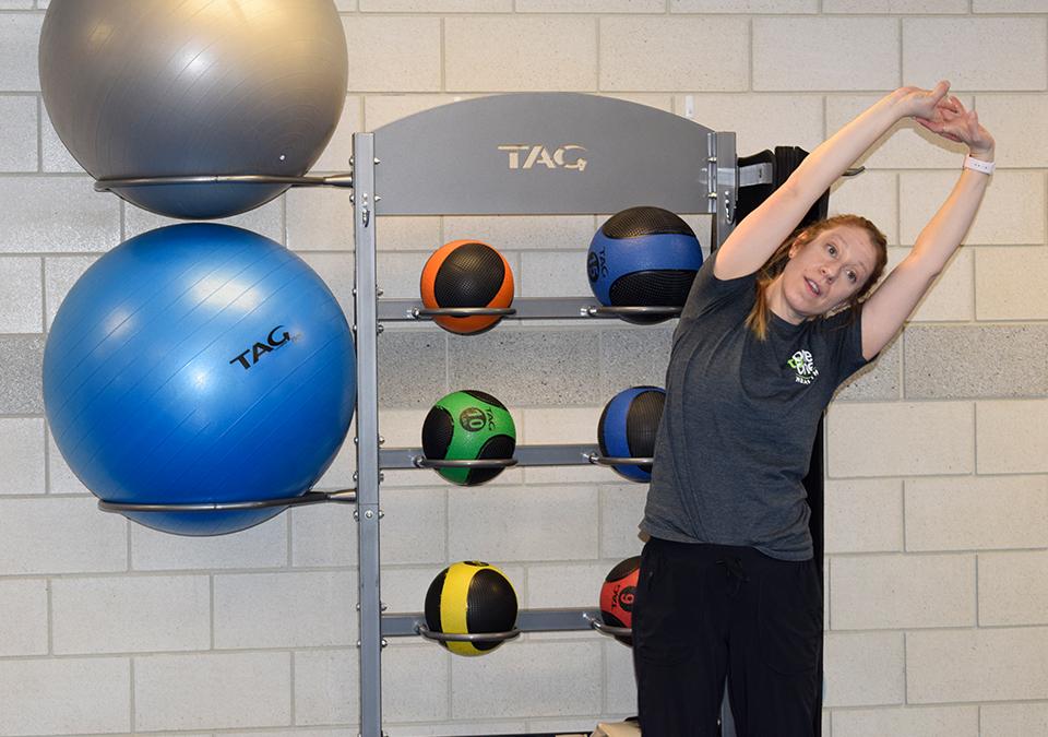 Health coach Lindsay Bloom showing a side stretching exercise