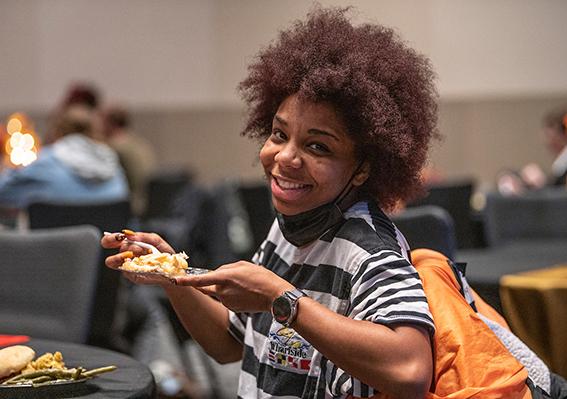 A student is eating a meal and smiling
