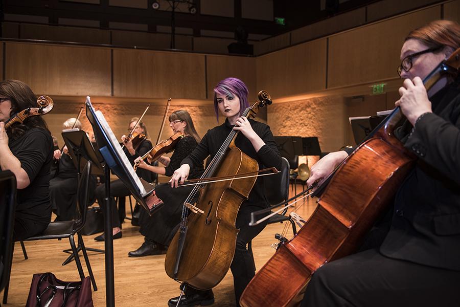 Musicians stand together playing instruments.