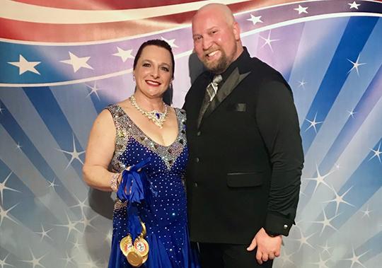 Chris Kuznar and her dancing instructor with the medals they won in a competition