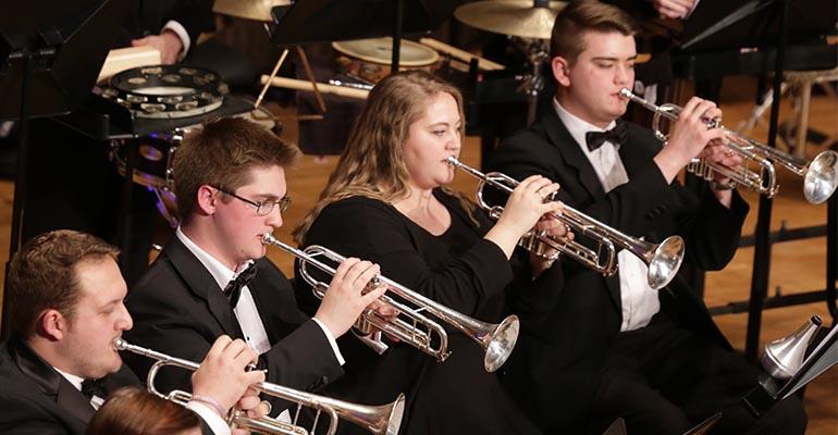 4 people playing trumpets