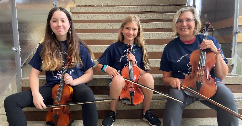 3 people on stairs with violins