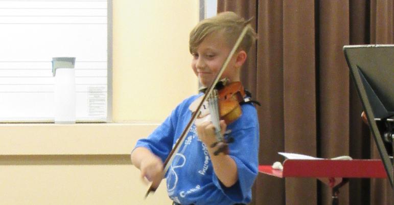 kid playing violin on stage