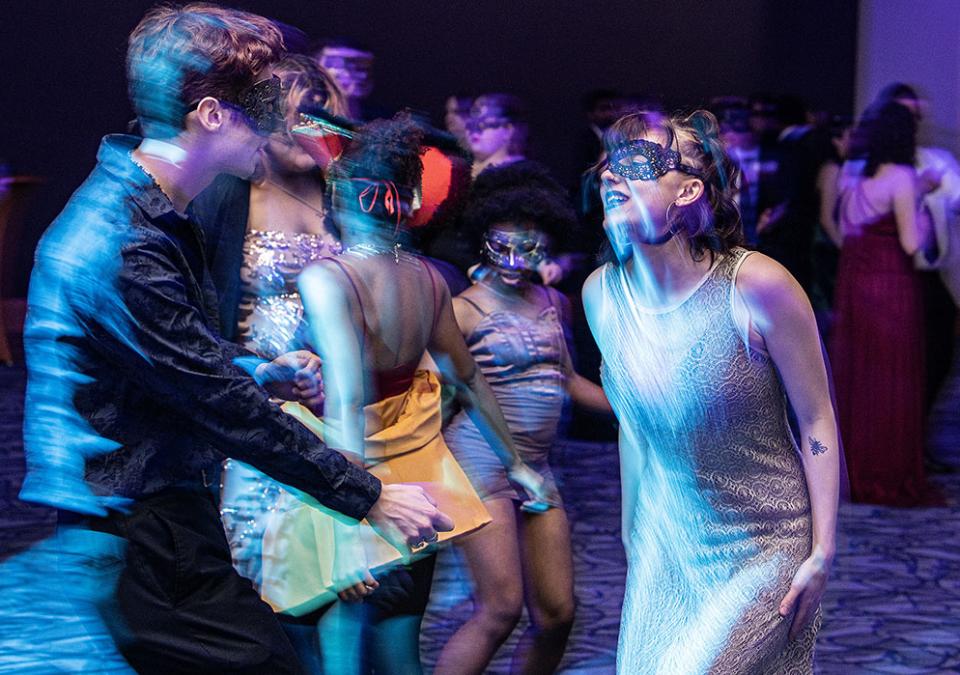 A couple is dancing at a masquerade ball