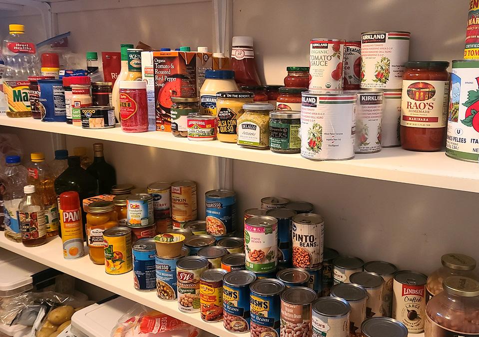 Close up of canned goods on a white pantry shelf