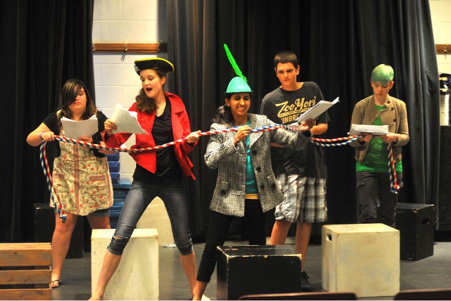 kids acting on stage with funny props