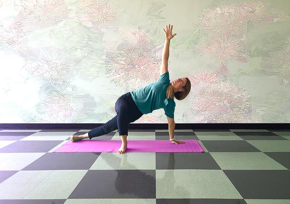 Yoga instructor doing a variation of a side plank yoga pose.