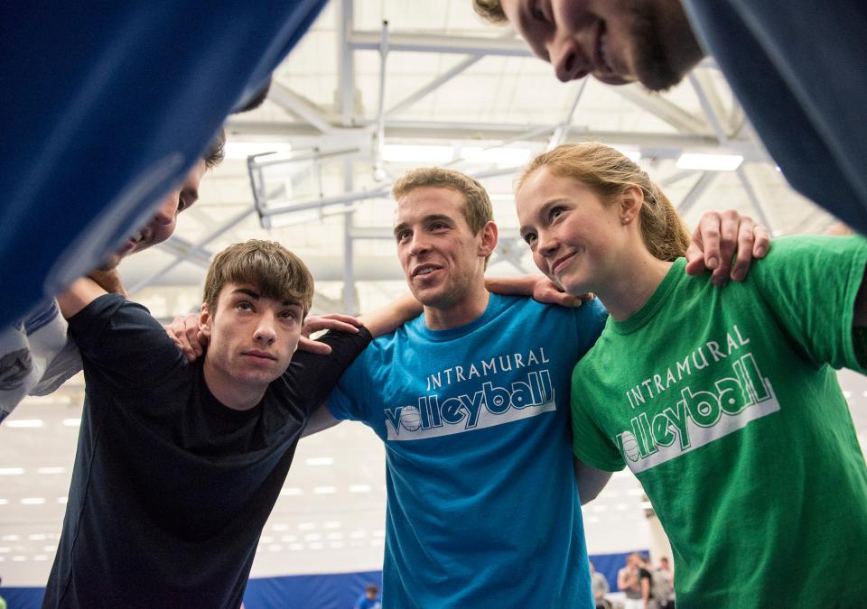 Students huddling during a volleyball match