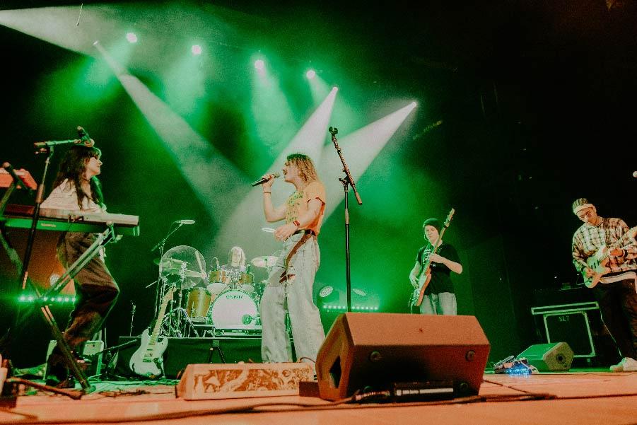 people singing on stage with green spotlights