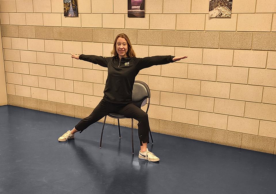 Chair yoga instructor demonstrating the seated warrior pose