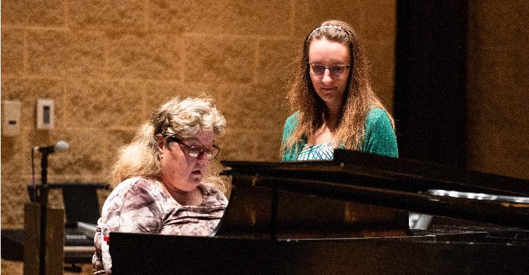 two women playing piano