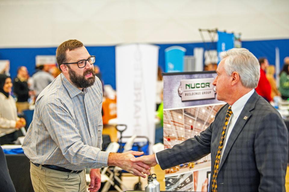 Chancellor shaking hands with a guest at the career expo.