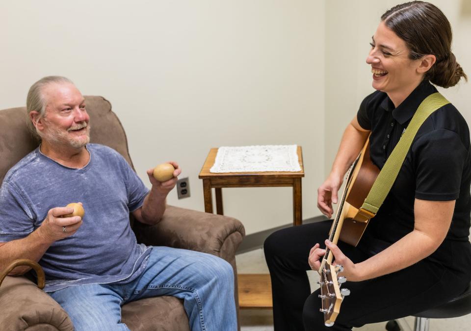 Music Therapist plays guitar for client