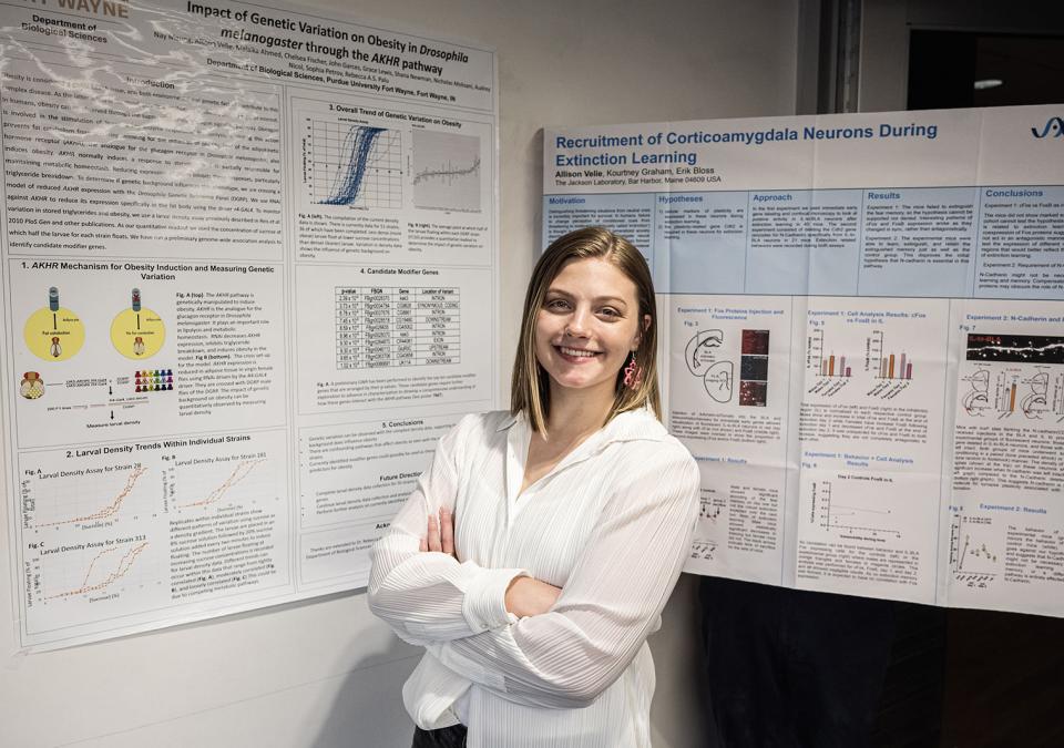 Allison Velie is standing in front of posters