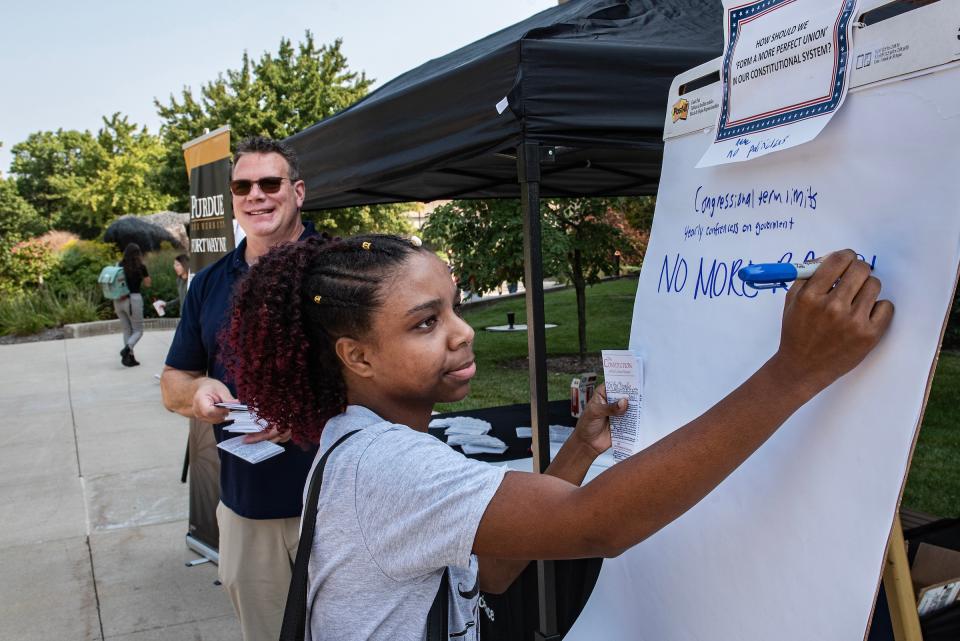 Student writes on a poster about Constitution Day.