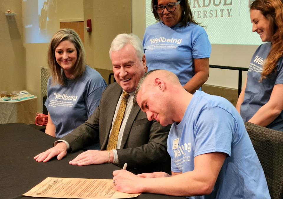Eric Manor, associate chief of campus and community wellbeing, adds his signature to the charter.
