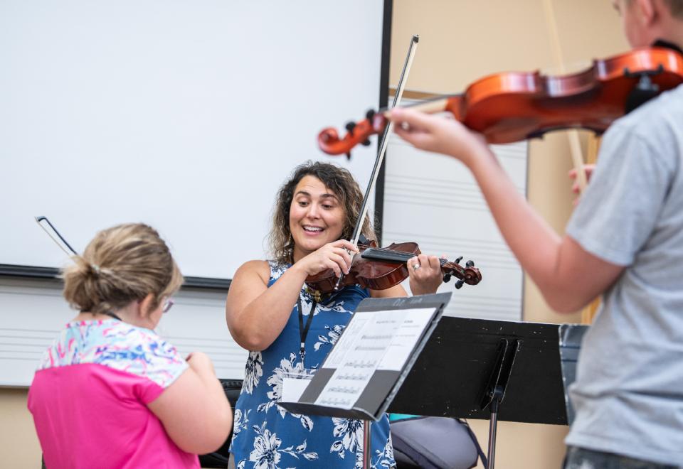 woman educating violin students
