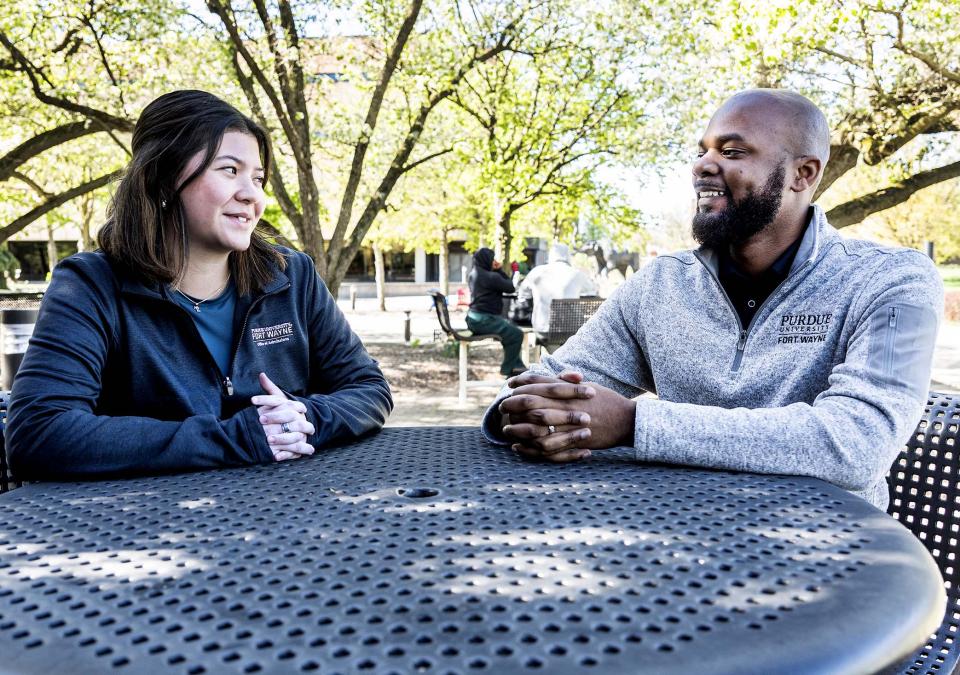Madeline Minobe and DeShawn Woods are sitting at a table