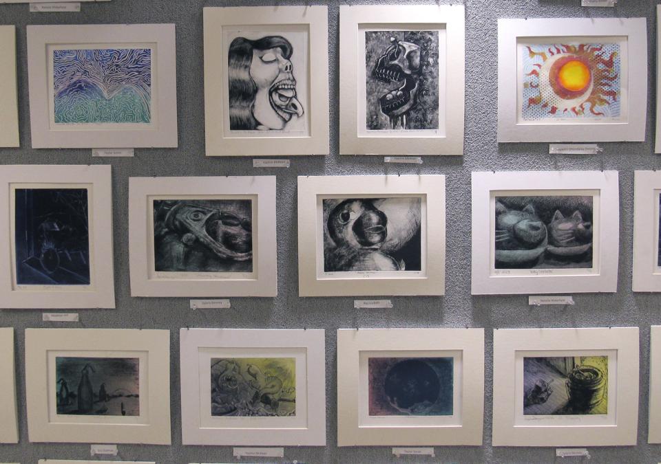a wall of student framed student artwork