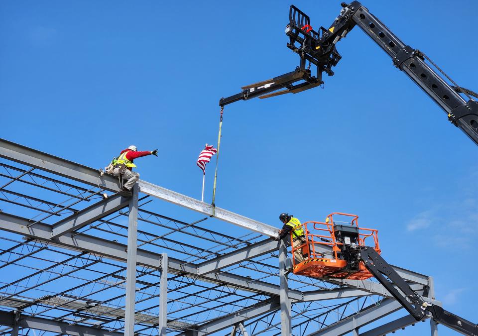 The final beam  is placed atop the Music Industry building