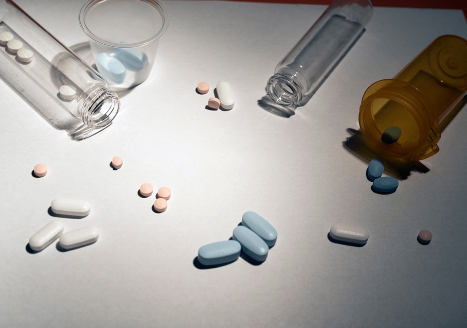 Several pills surrounded by vials