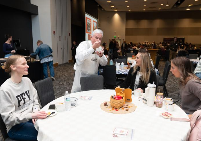 Chancellor Ron Elsenbaumer is visiting with students at a table