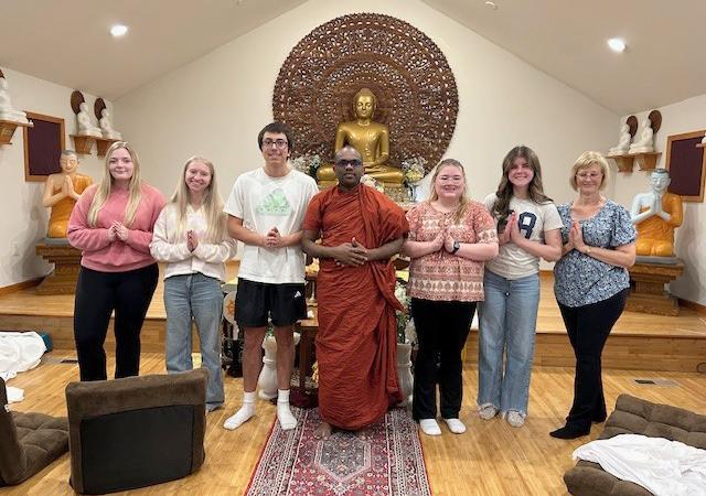 Sociology students with a Buddhist monk in a temple