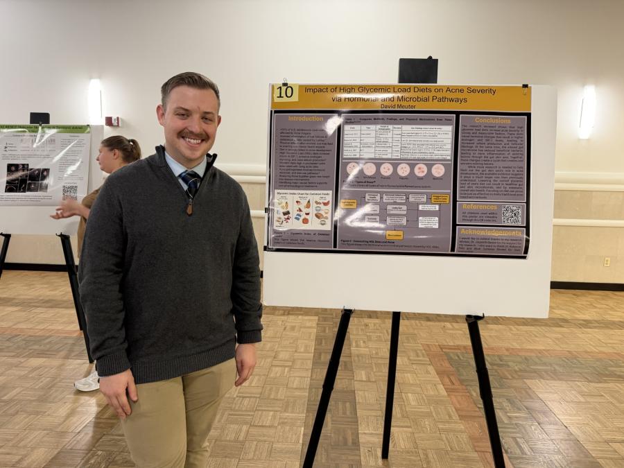 Photo of student in front of Senior Seminar Research Poster