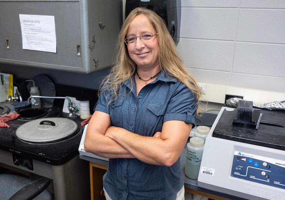 Jackie Miller is in a lab with her arms crossed