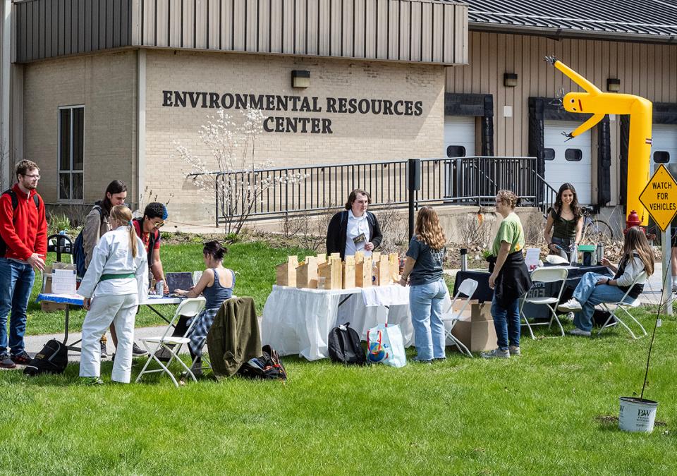 Several people are at tables outside of the Environmental Resources Center