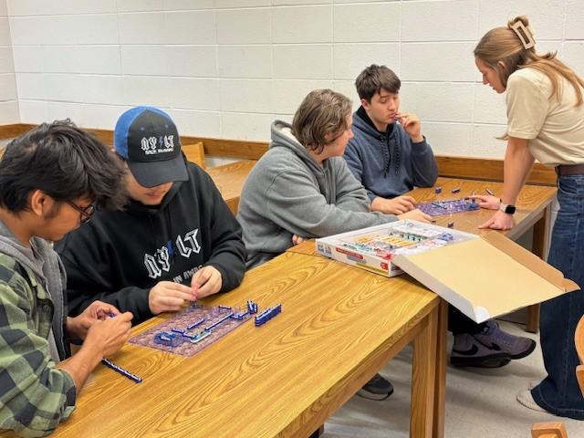 High school students doing circuit connection activity with student ambassador