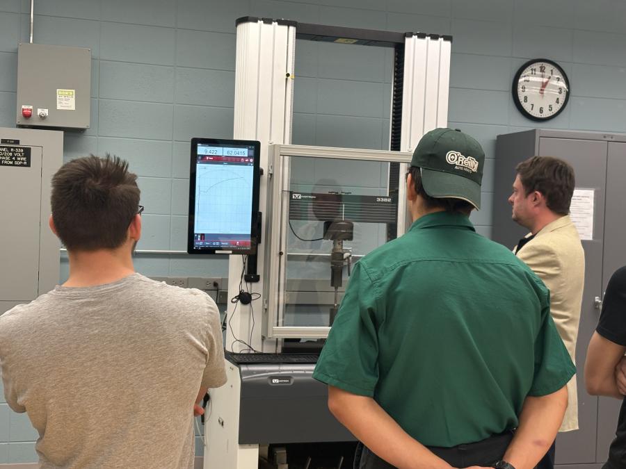 Professor showing machine to high school students