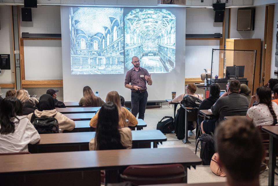 Professor providing instruction to a group of students.