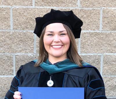 Photo of Chelsey Barrow in doctoral academic regalia.