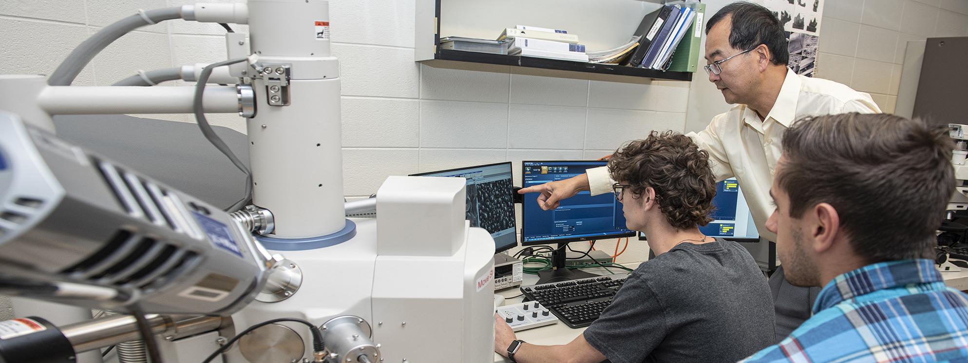 Students working in an engineering lab with a professor.