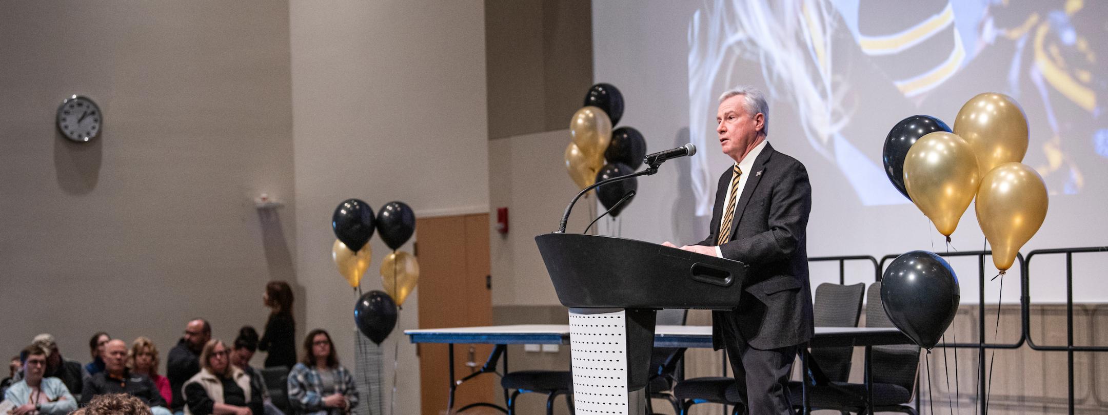 The chancellor gives a speech on stage.
